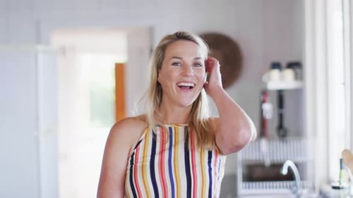 Blonde Woman Smiling and Laughing in Kitchen