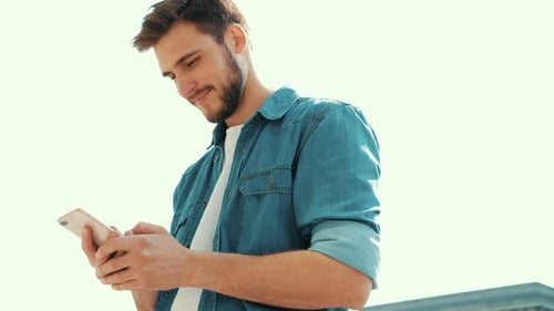 Young Man Using Phone in Urban Setting