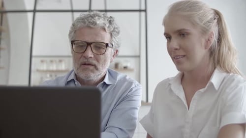 Man and Woman Discussing Laptop at Workplace