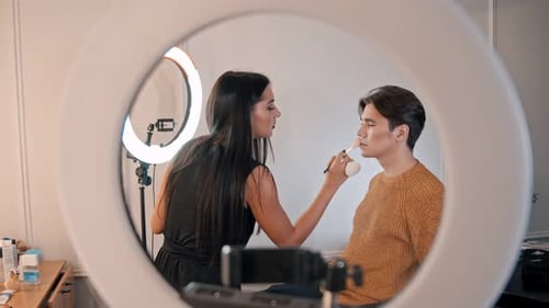 Makeup Studio - Woman Artist Highlighting the Upper Lip of Her Male Model
