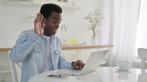 African Man Doing Video Call on Laptop at Home