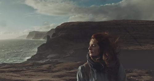 Woman Looks Out Over Stormy Coastal Landscape