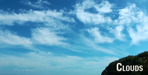 Wispy Clouds Over Green Hillside and Blue Ocean