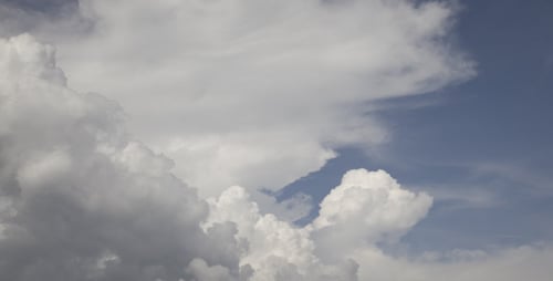 Fluffy Clouds Floating across a Blue Sky