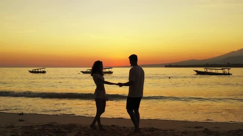 couple in love dancing on the sandy beach at sunset, bali, Indonesia