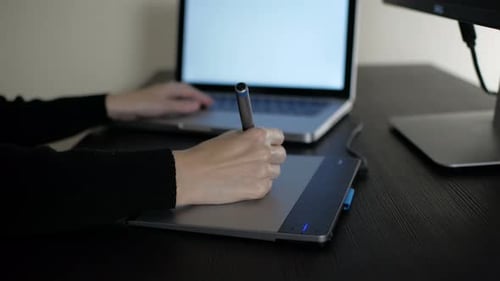Graphic Designer Uses Tablet and Stylus at Desk