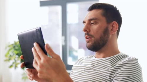 Man Video Chatting on Tablet at Home