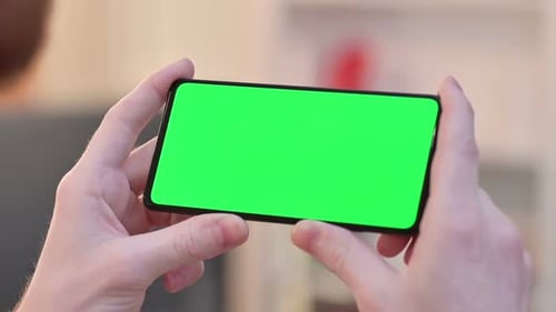 Hands Holding Phone with Green Screen in Landscape