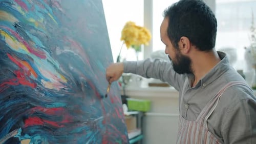 Man Painting Abstract Artwork in Bright Studio