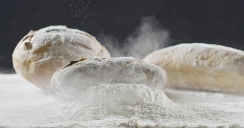 Bakery and Cooking Concept. Fresh Bread with a Splash Falls Into Flour