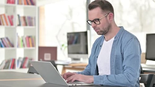 Man Working on Laptop at Office Desk