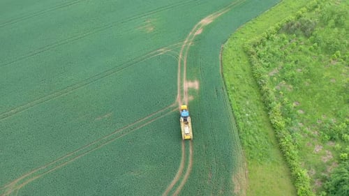 Aerial view of farming tractor crop sprayer in the countryside