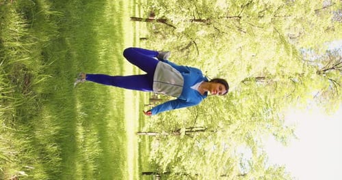 Vertical Video of a 35 Year Old Woman Practices Yoga in a City Park