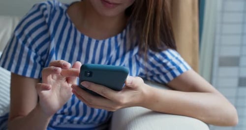 Young Adult Using Mobile Phone on Couch