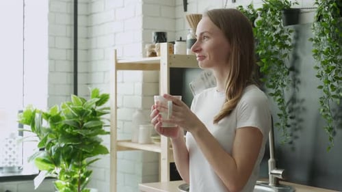 Woman Drinking Coffee in Bright Airy Kitchen