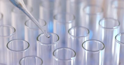 Liquid Dropped into Test Tubes in Laboratory Setting