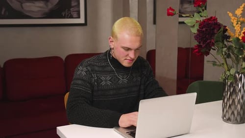 Young Adult Typing on Laptop at Home