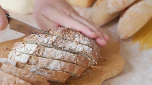 Slicing Fresh Whole Wheat Bread on Cutting Board