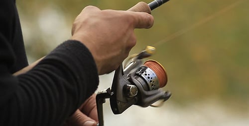 Close-up of Man Fishing with Rod and Reel