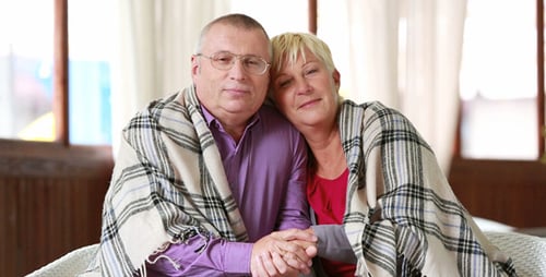 Loving Couple Holding Hands While Sitting Indoors