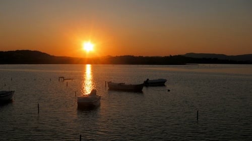 Sunset Over Water With Boats in Silhouette