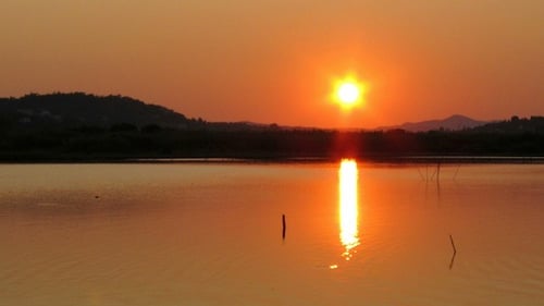 Golden Sunset Over Water Reflecting on Lake