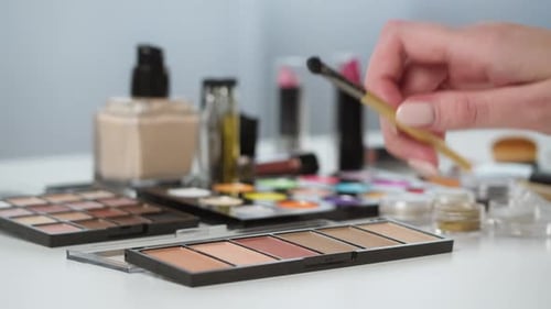 Hand Swirling Makeup Brush on Colorful Eye Shadow