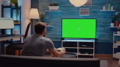 Hombre viendo la televisión con pantalla verde