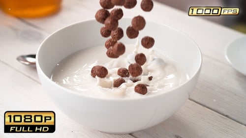 Breakfast cereal and blueberries falling into milk