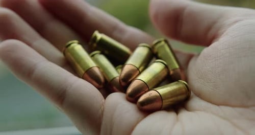 Close Up of 9mm Handgun Bullets in a Man's Hand