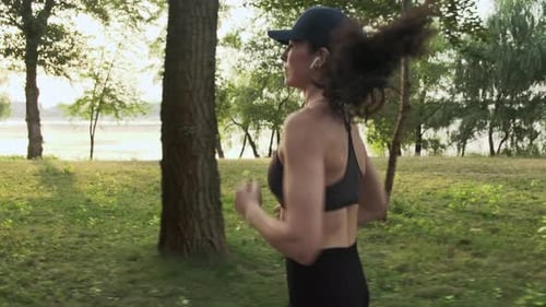 Woman Jogging on Trail in Park on Sunny Day