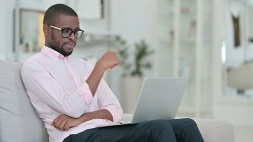 Man Working on Laptop at Home on Couch