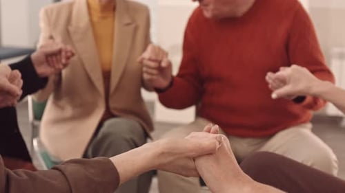 Seniors Holding Hands in Supportive Group Meeting