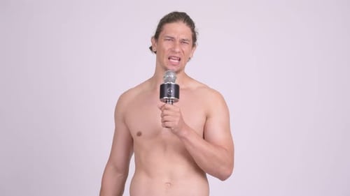 Shirtless Man Speaking Angrily Into Microphone