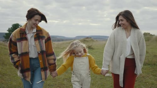 Family Walking Together in a Grassy Field