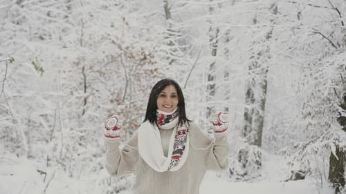 Beautiful Young Woman Walking in a Cold Winter Forest During a Little snowfall
