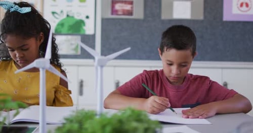 Students Writing at Desks in School Classroom