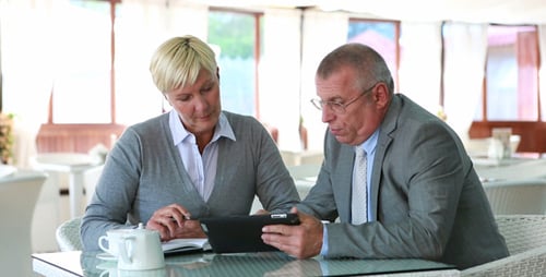 Business Colleagues Discussing Data on a Tablet Indoors