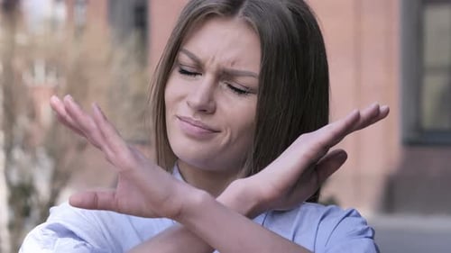 Woman Expressing Rejection With Arms Crossed and Headshake
