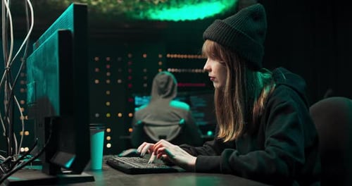 Woman Coding at Computer in Dark Office