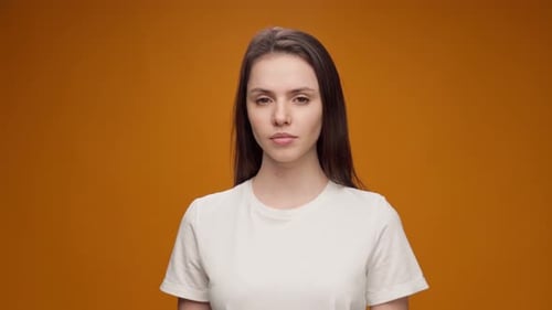 Young Woman in T-shirt Stares at Camera