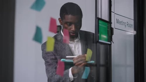 Man Writes on Tablet in Modern Office