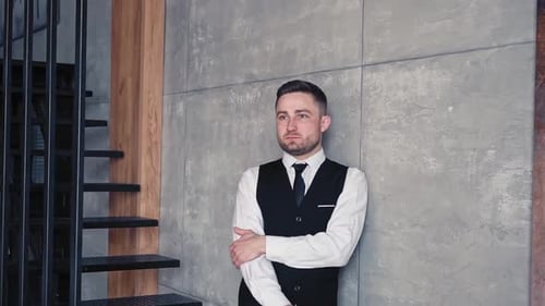 Man in Vest Standing Near Industrial Loft Wall
