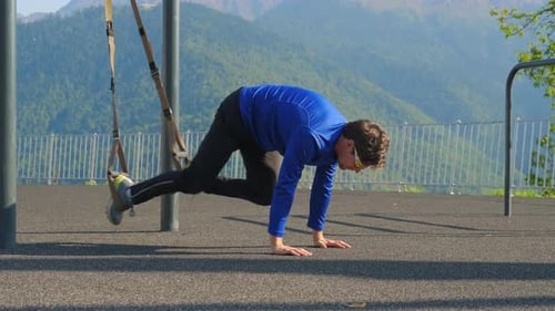 Man Exercising with TRX Straps in the Mountains