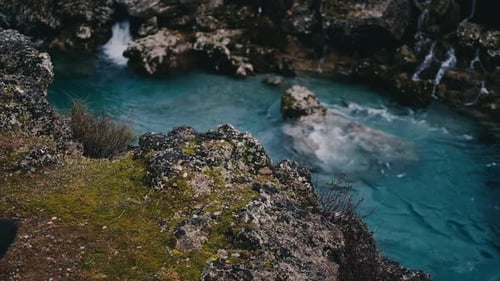 Men's legs are on the edge of Niagara Waterfall on the river Cijevna on cloudy weather