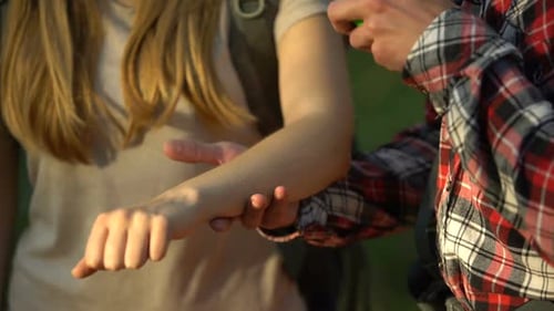 Man Sprays Insect Repellent on Woman's Arm Outdoors