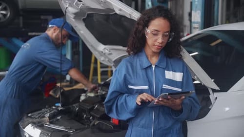 Team of mechanic with man in uniform fix and repair engine car and woman holding tablet computer.