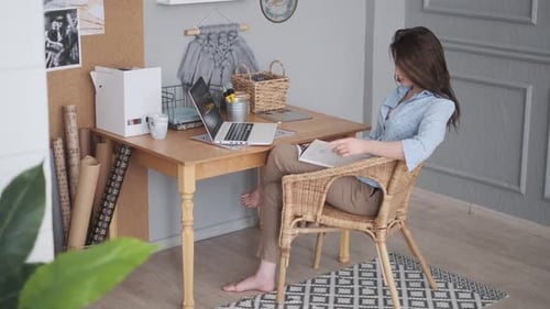 Freelancer Reads Magazine in Home Studio