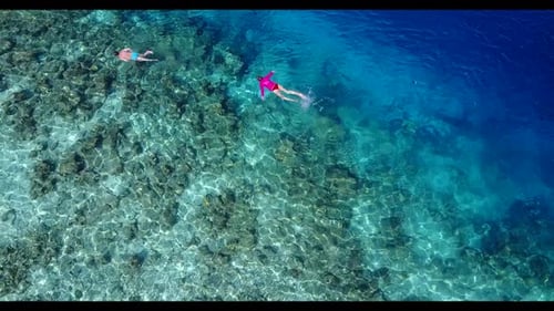 Boy and girl happy together on tropical bay beach voyage by blue ocean with white sandy background o