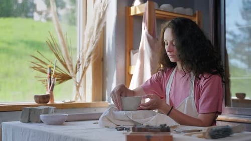 Woman Shaping Clay Bowl in Studio
